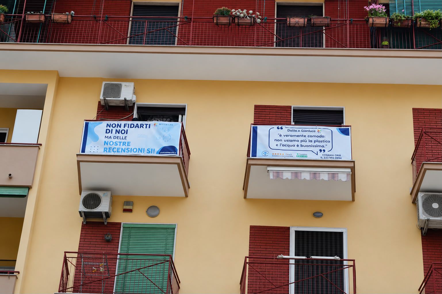 Facciata residenziale con due banner pubblicitari montati sui balconi