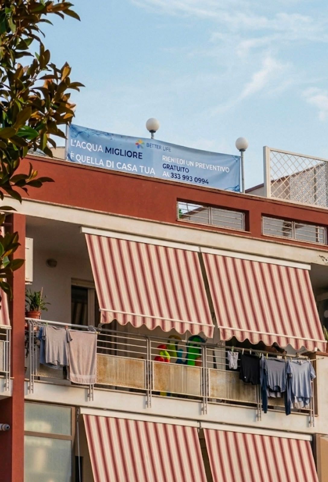 Banner pubblicitario installato sul parapetto di un edificio rosso e bianco